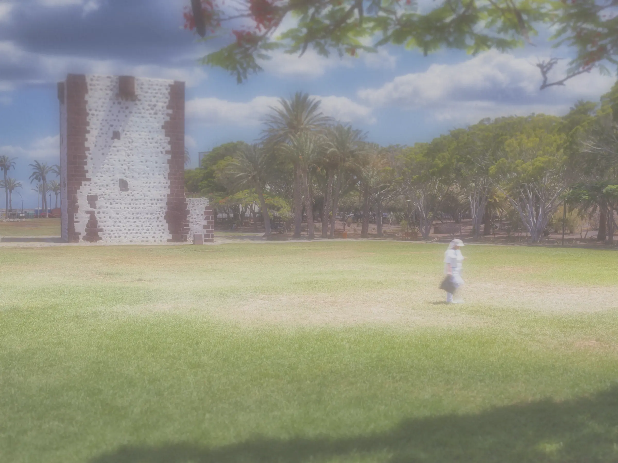 "A dreamy, soft-focus shot of an elderly woman taking a peaceful walk through a green park, with the ancient Torre del Conde castle blurred beautifully in the background."
